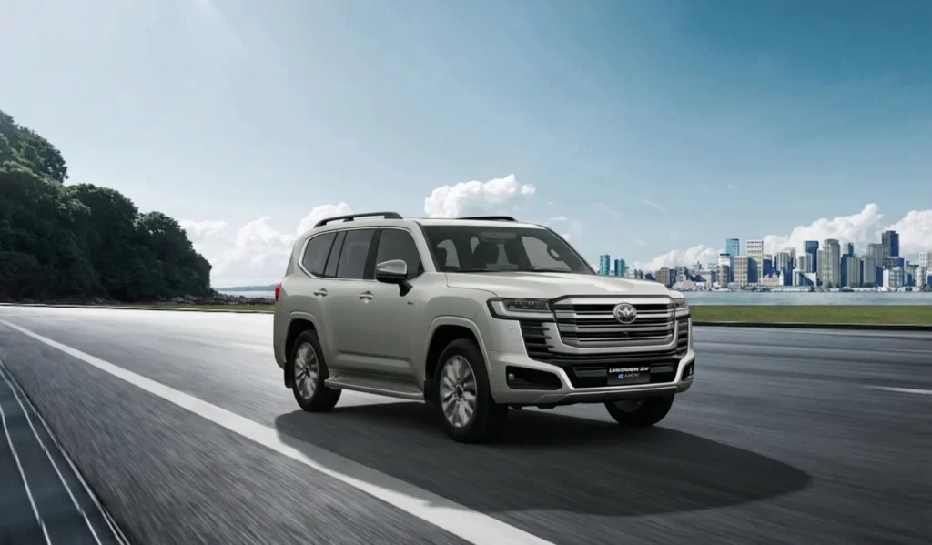 Toyota Land Cruiser 300 en marcha con la ciudad al fondo