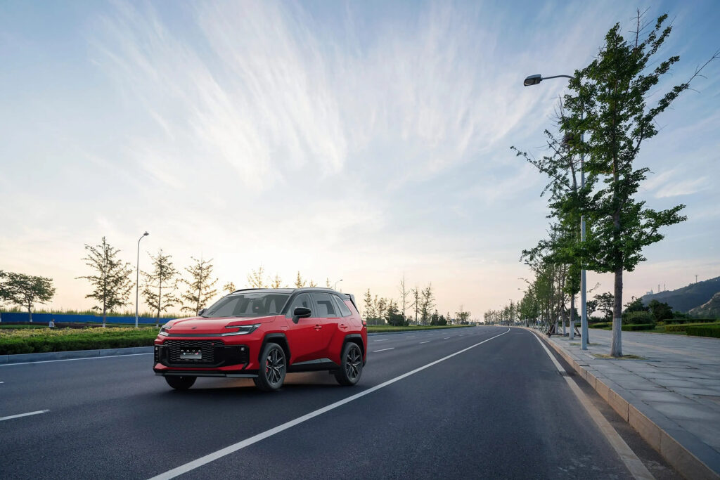 Toyota RAV4 PHEV GR-S en rojo por una avenida arbolada